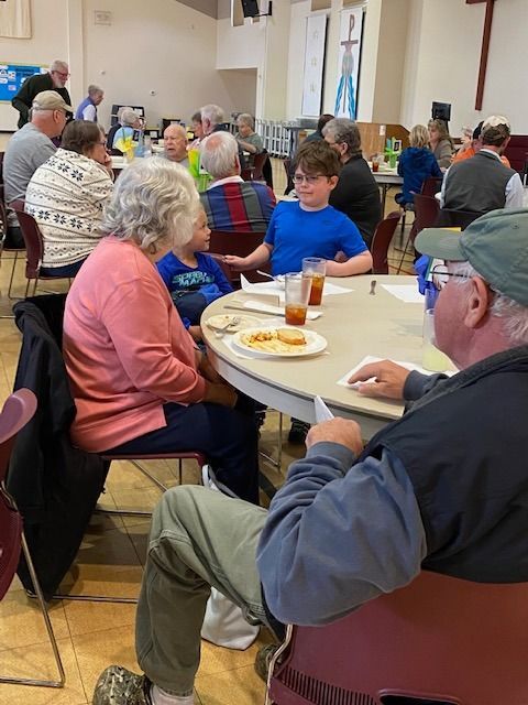 A group of people are sitting at tables in a room.