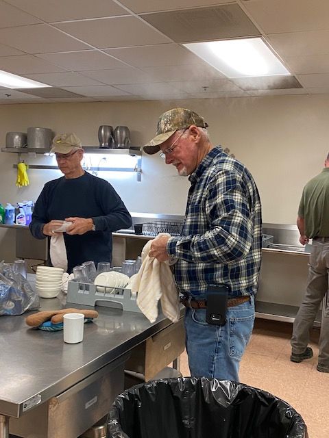 Two men are standing in a kitchen cleaning dishes.