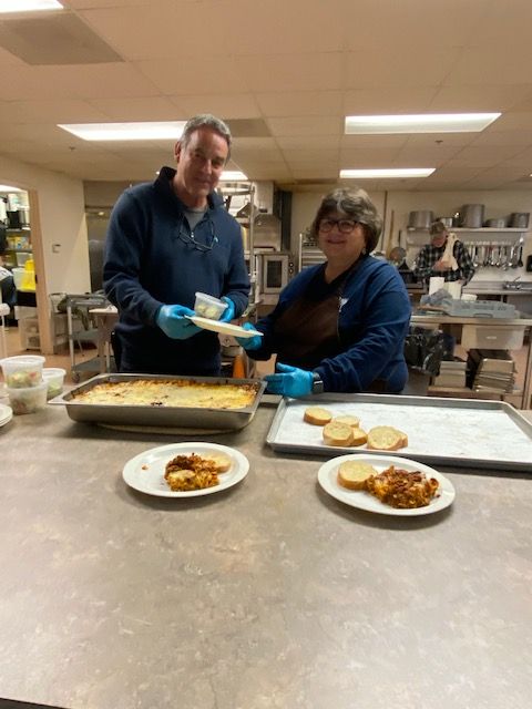 A man and a woman are preparing food in a kitchen.