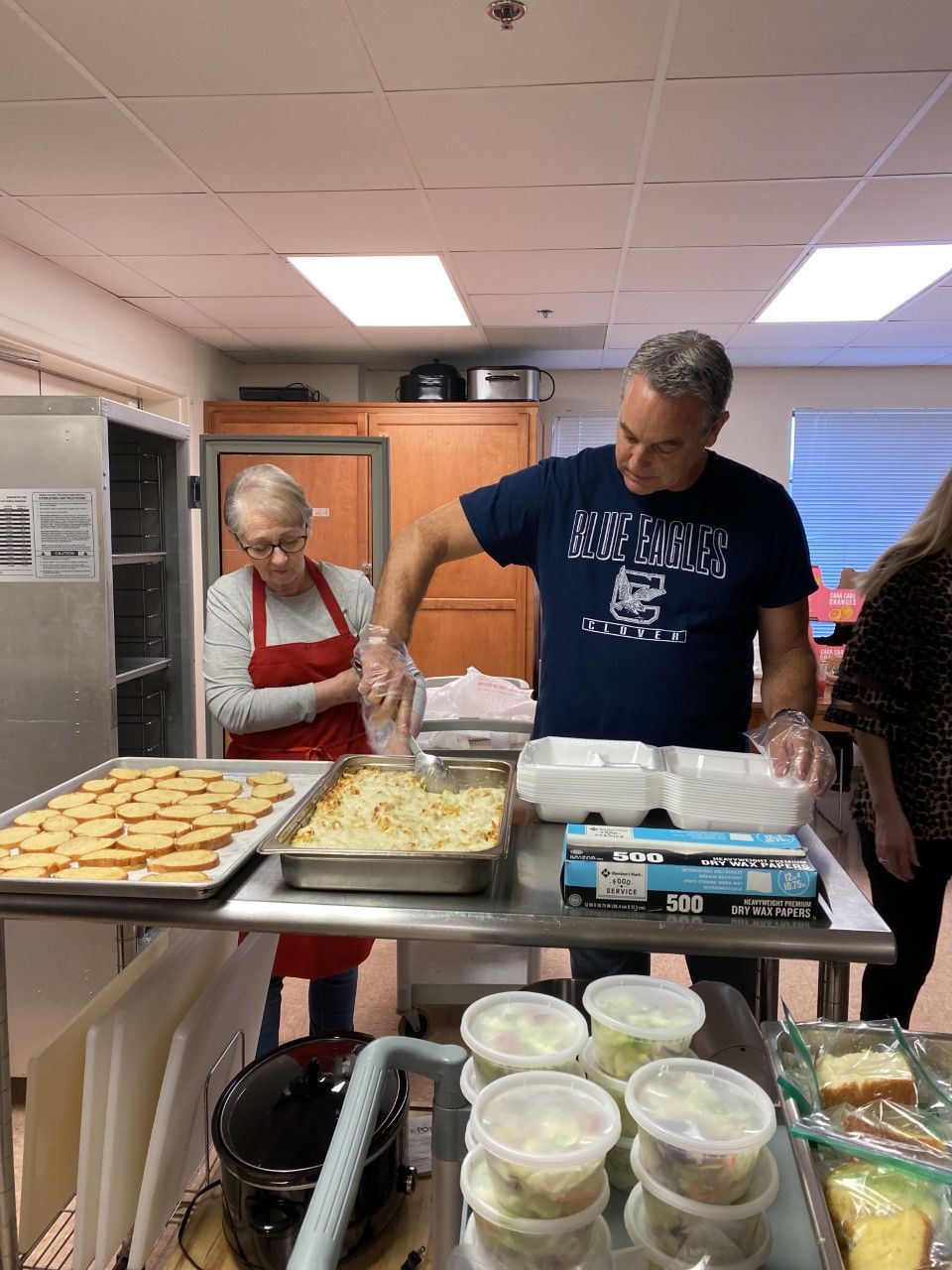 A man and a woman are preparing food in a kitchen.