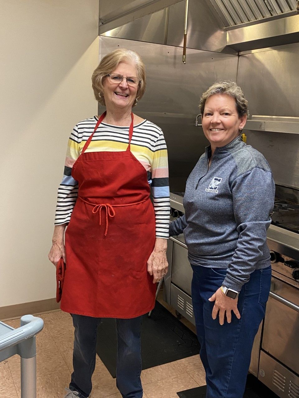 Two women are standing next to each other in a kitchen.