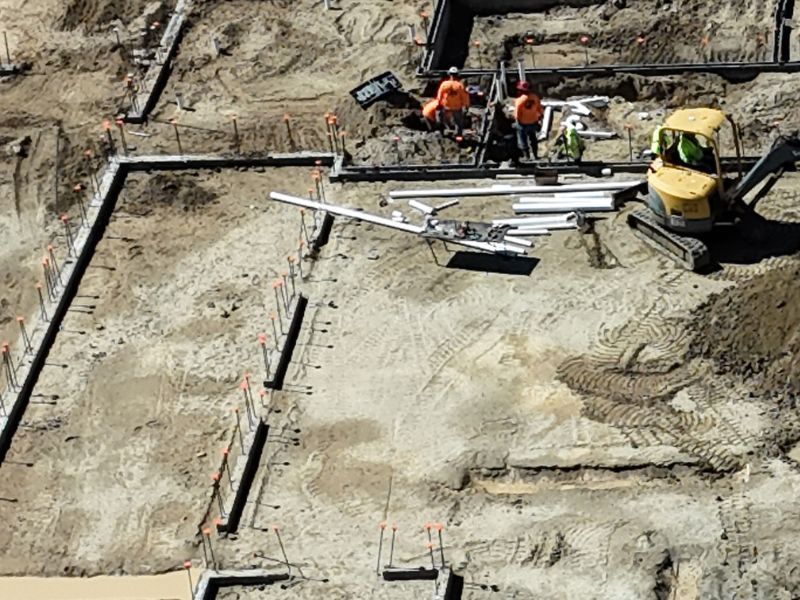 An aerial view of a construction site with workers and a bulldozer.