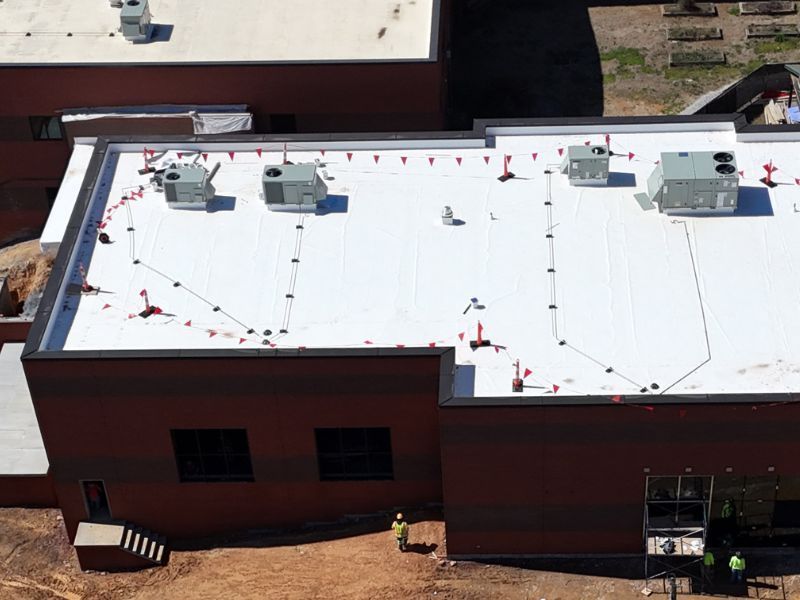 An aerial view of a building with a white roof