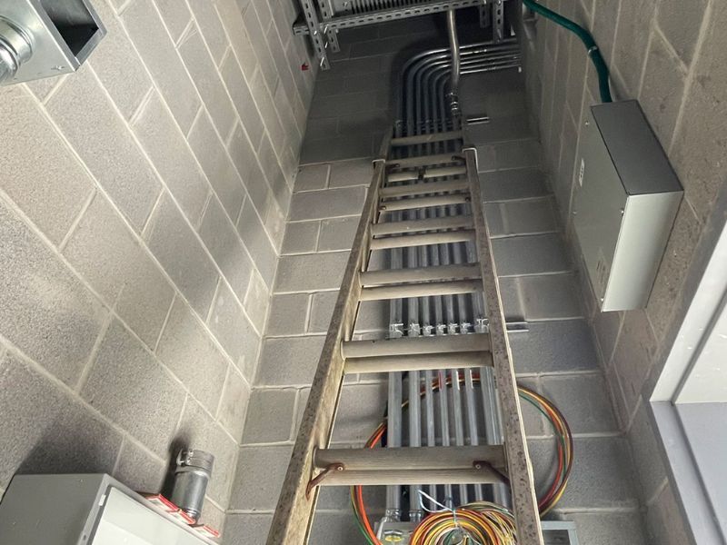 A ladder is hanging from the ceiling of a building.