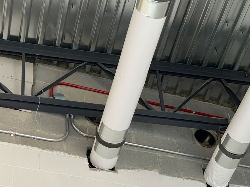 A couple of pipes are hanging from the ceiling of a building.