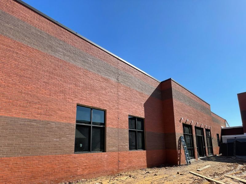 A brick building with a lot of windows is being built.