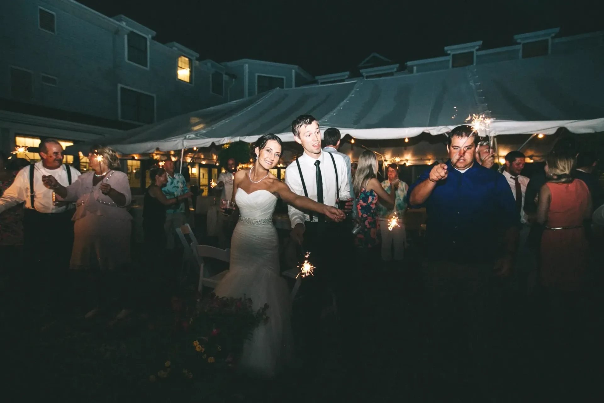 A bride and groom are dancing under a tent at their wedding reception.