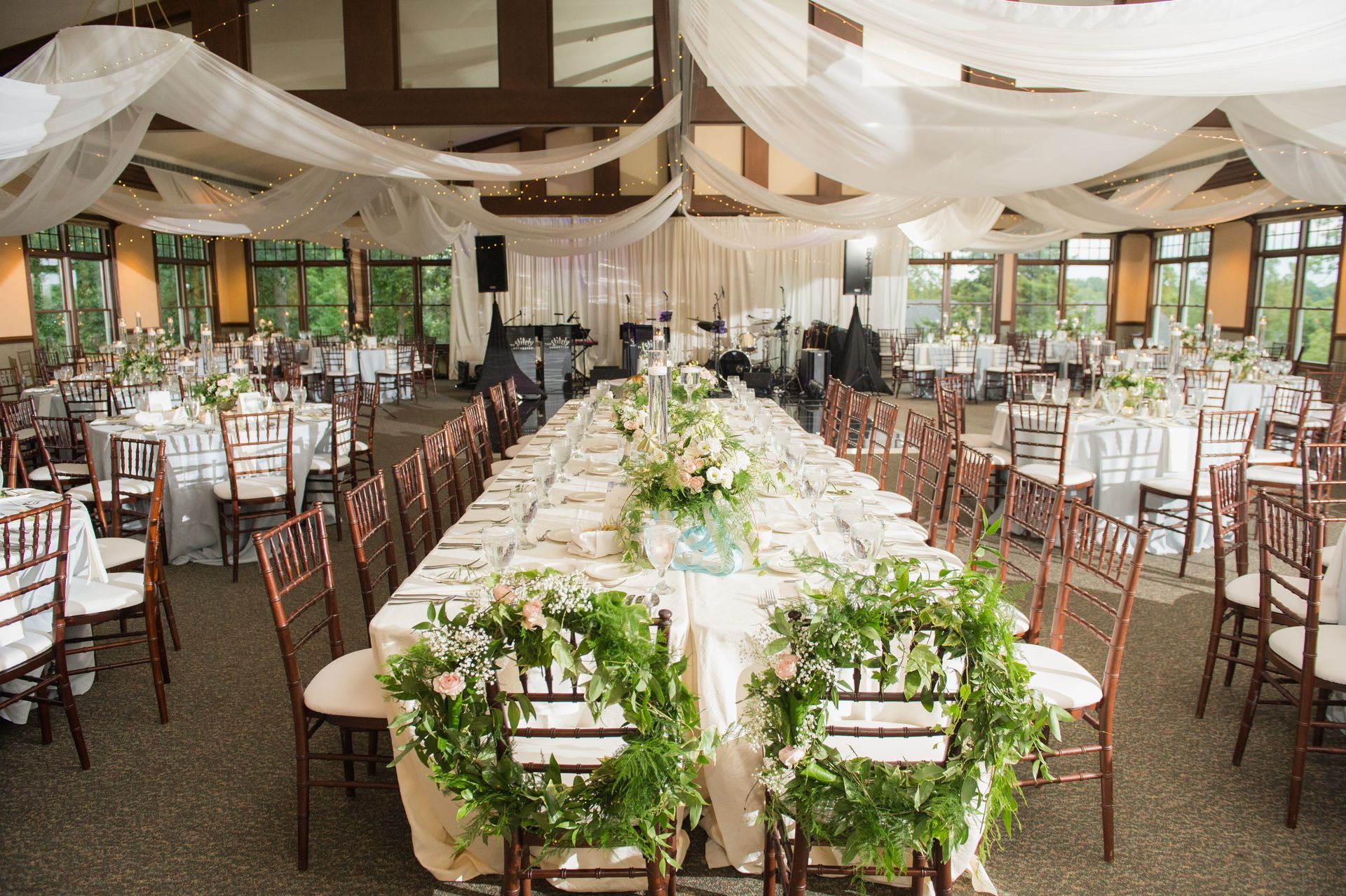 A large room with tables and chairs set up for a wedding reception.