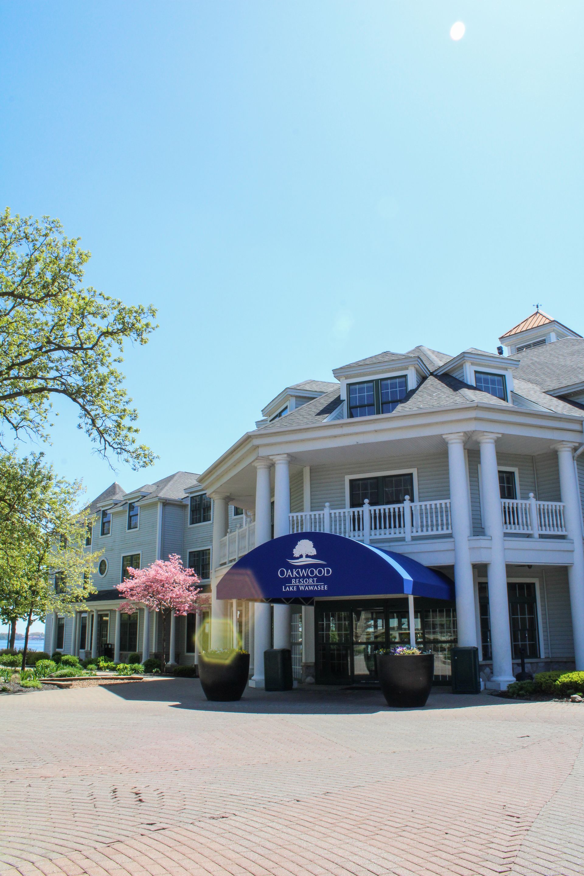 A large white house with a blue awning over the entrance