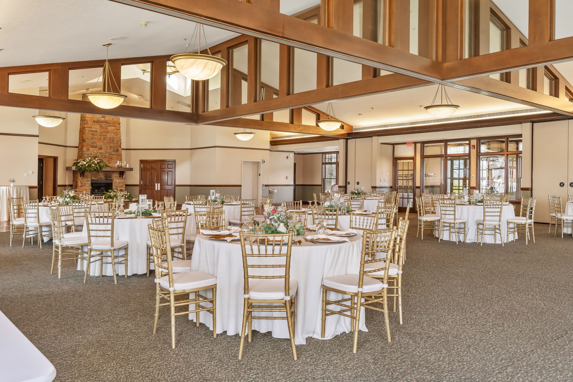 A large room with tables and chairs set up for a wedding reception.