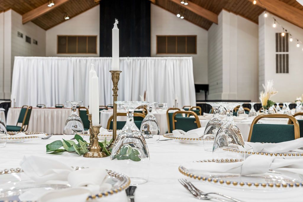 A large room with tables and chairs set up for a wedding reception.