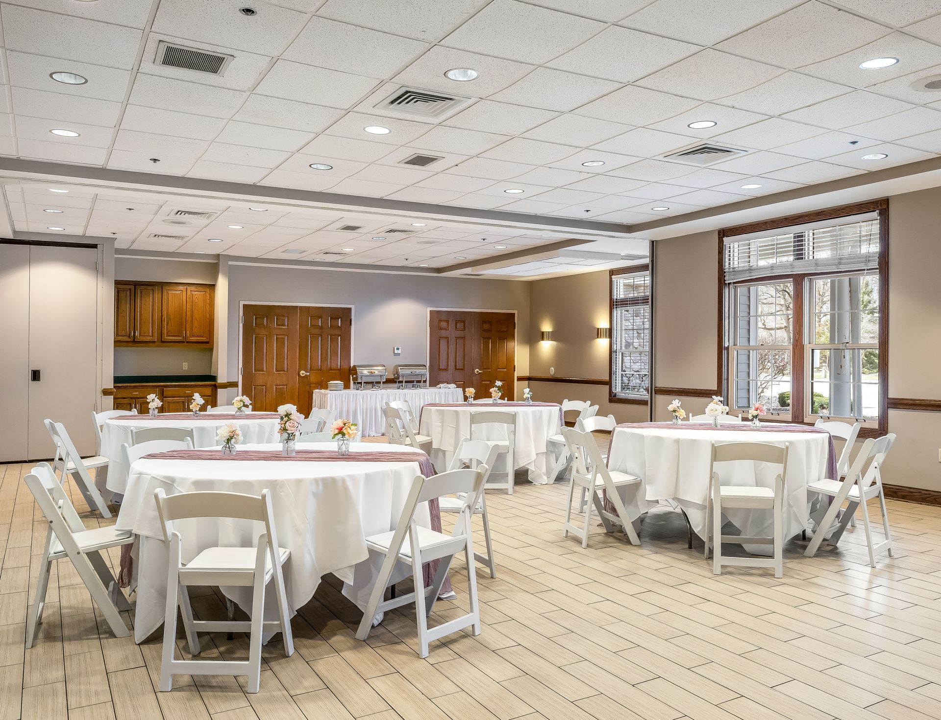 A large room with tables and chairs set up for a wedding reception.