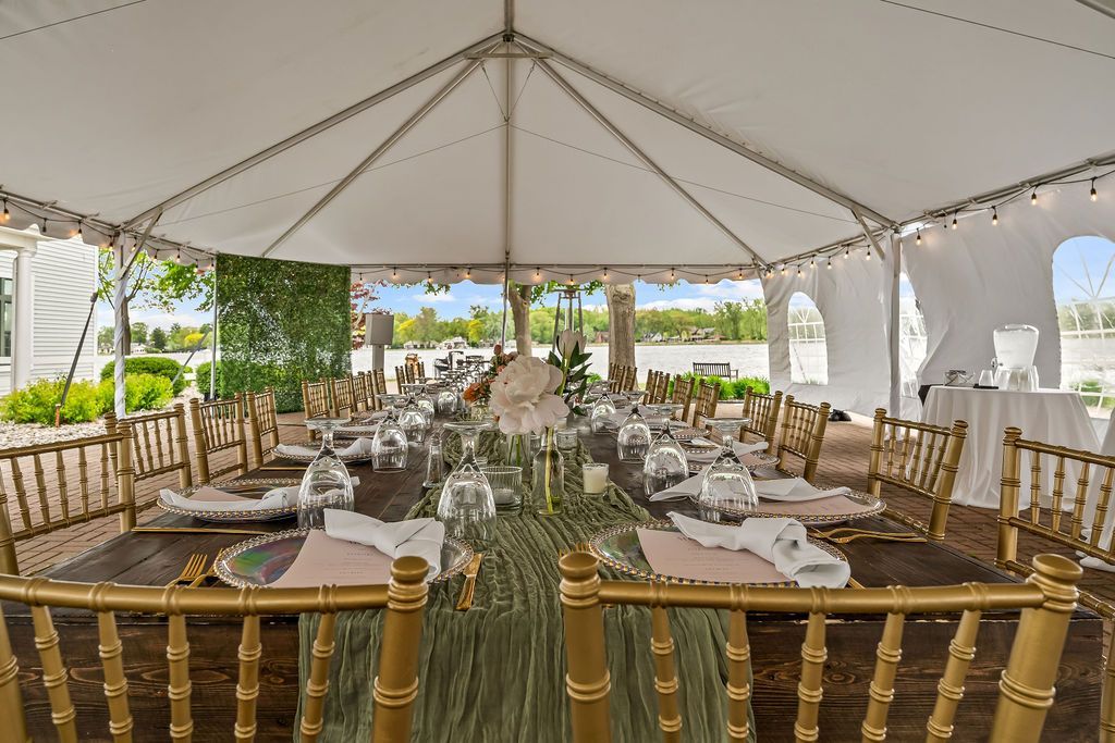 A large white tent with tables and chairs underneath it