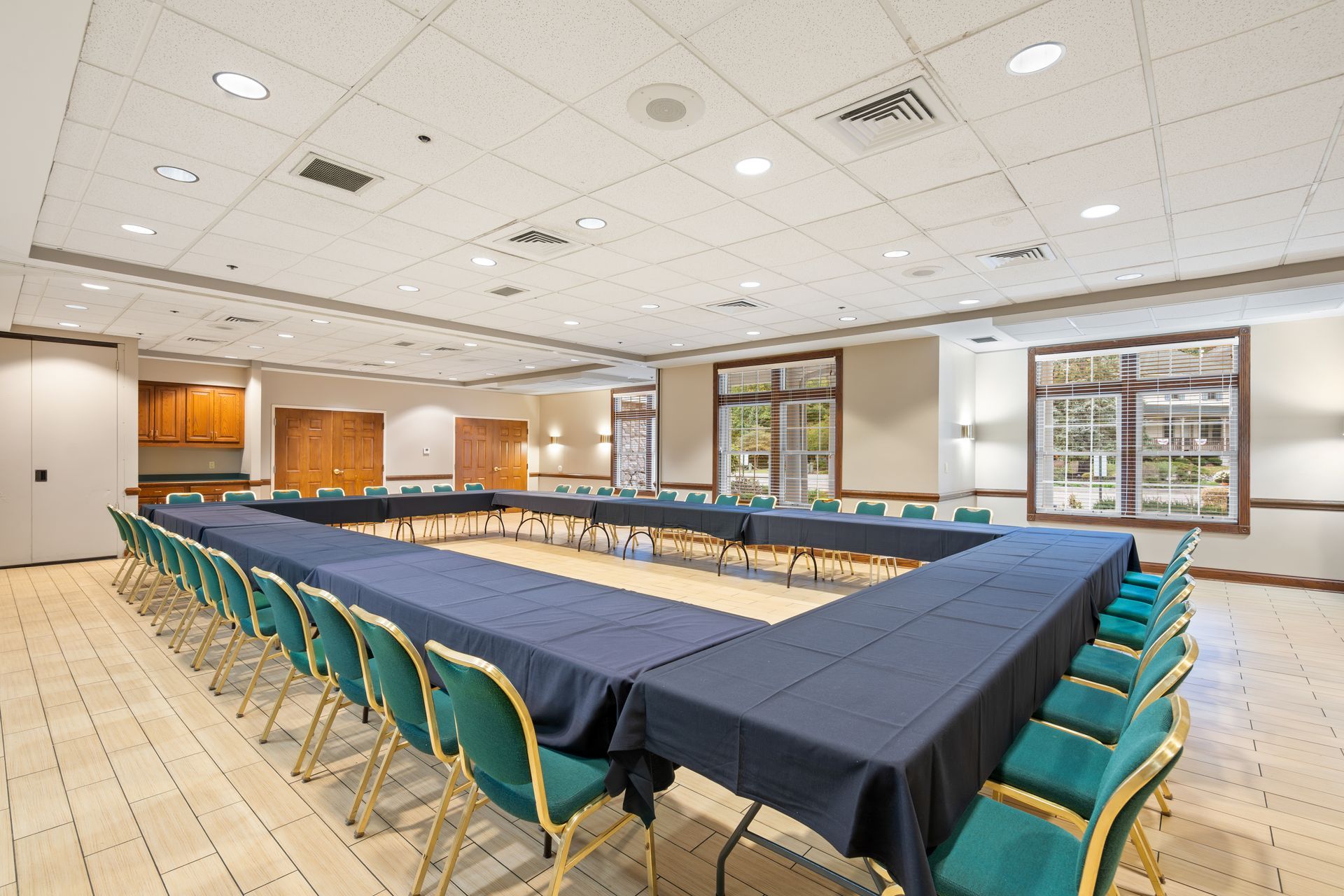 A conference room with tables and chairs arranged in a u shape