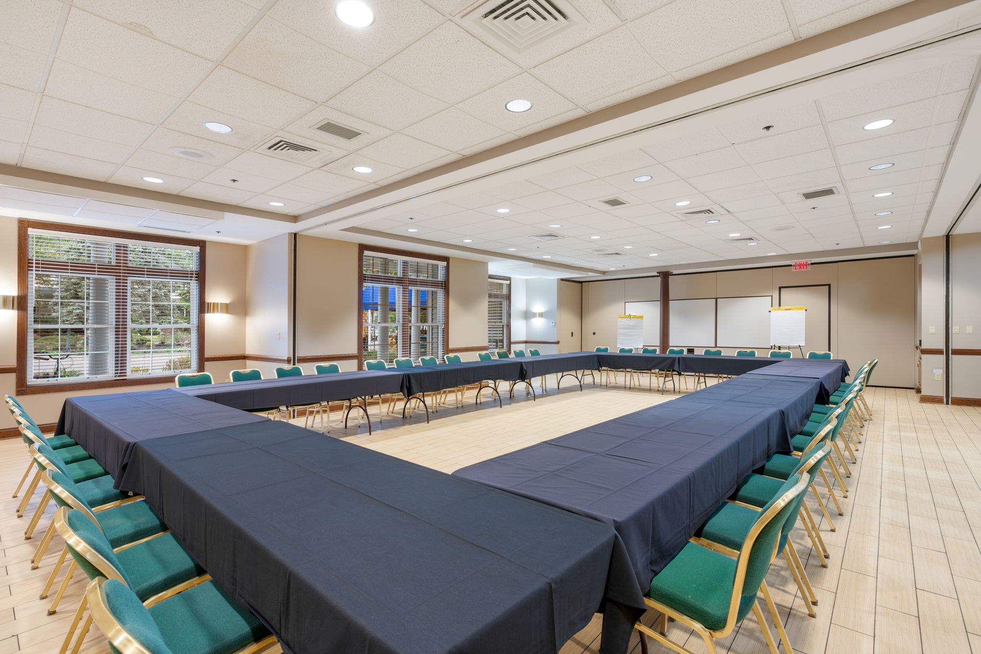 A large conference room with tables and chairs arranged in a u shape.