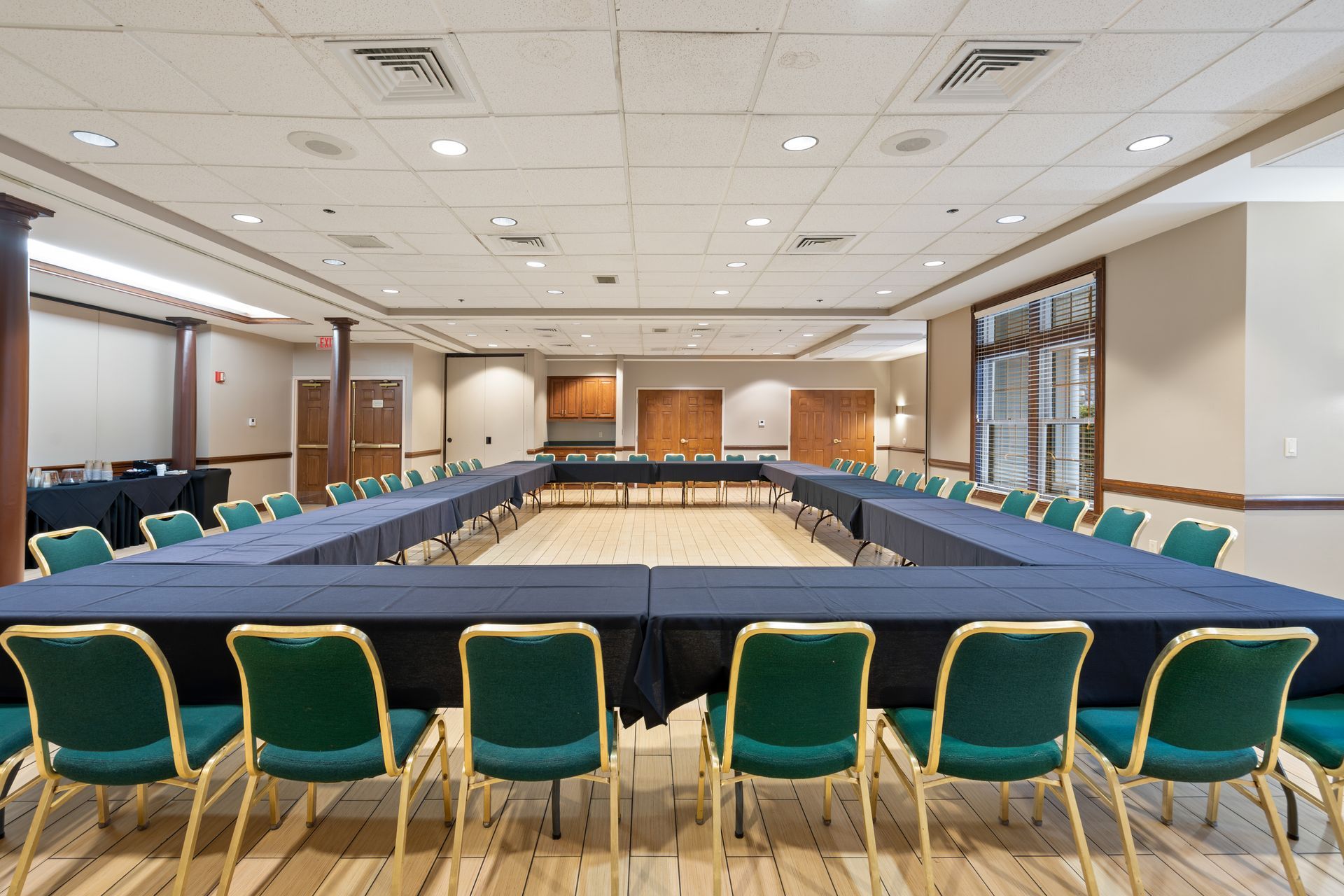 A large conference room with tables and chairs arranged in a u shape.