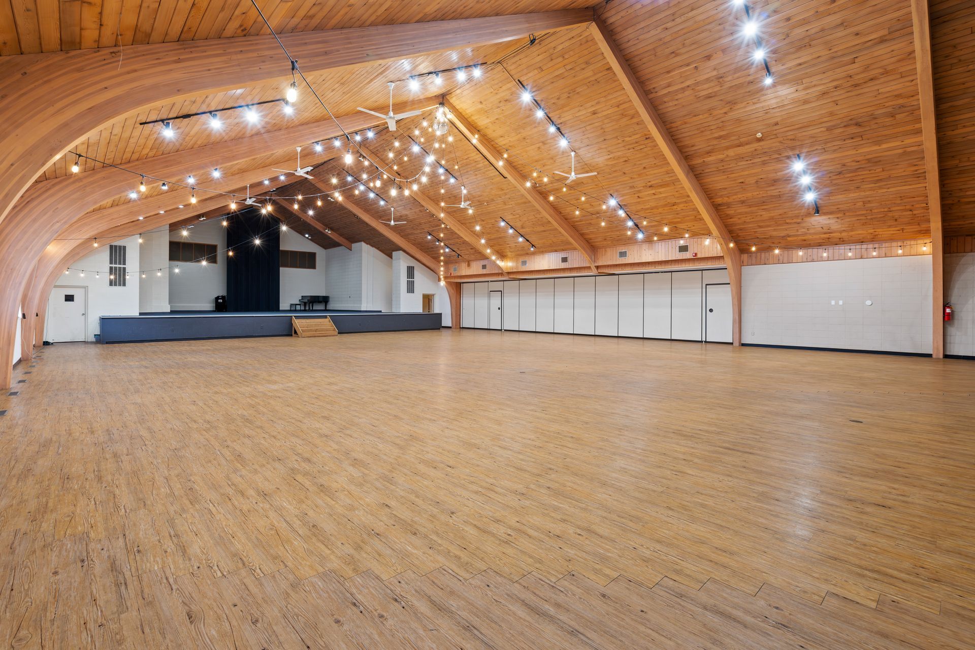 A large empty room with wooden floors and a wooden ceiling