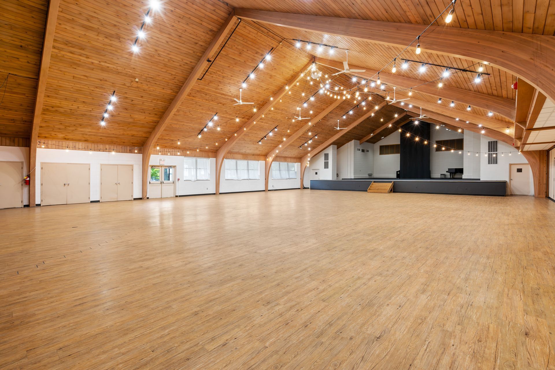 A large empty room with wooden floors and a wooden ceiling.