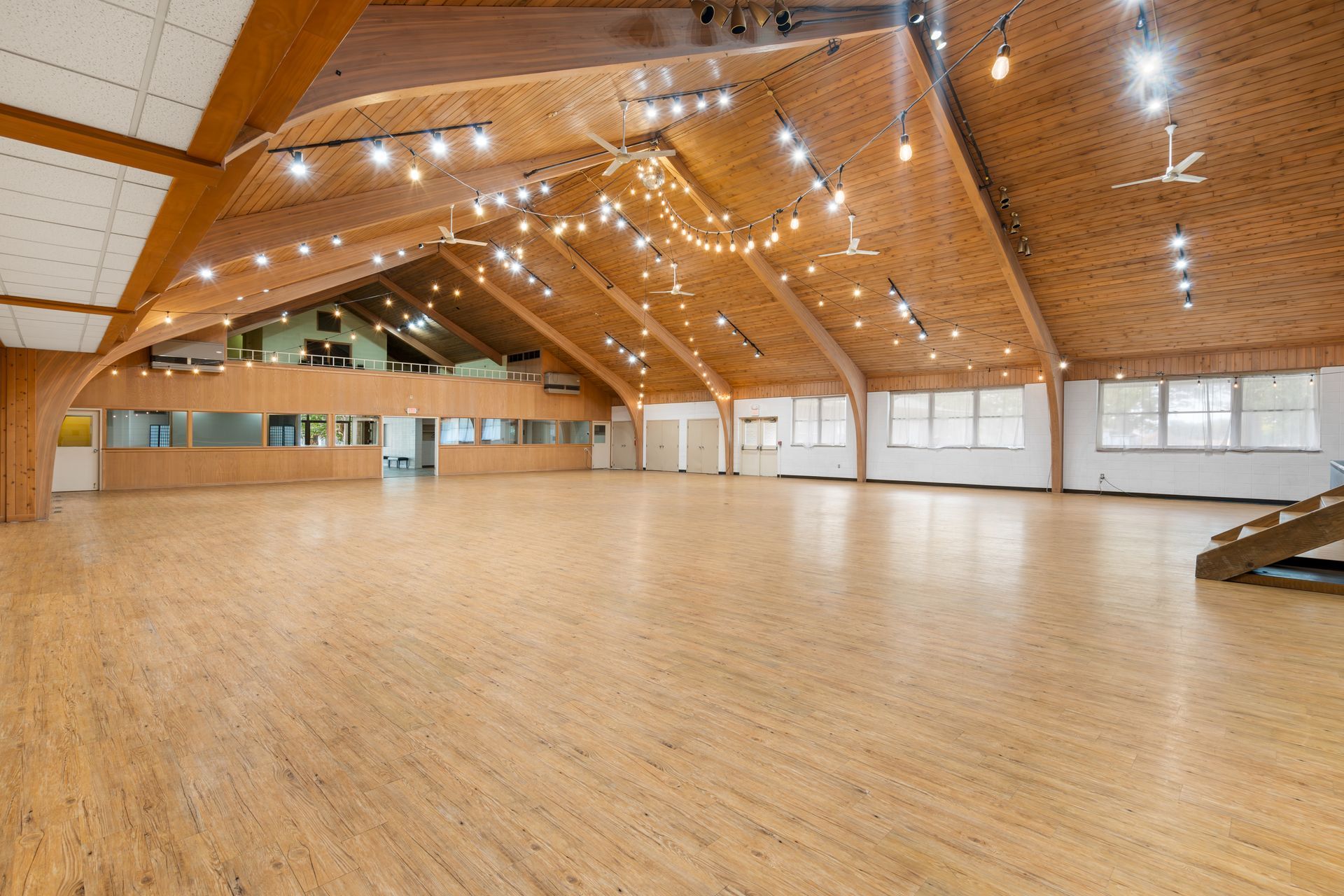 A large empty room with wooden floors and a wooden ceiling