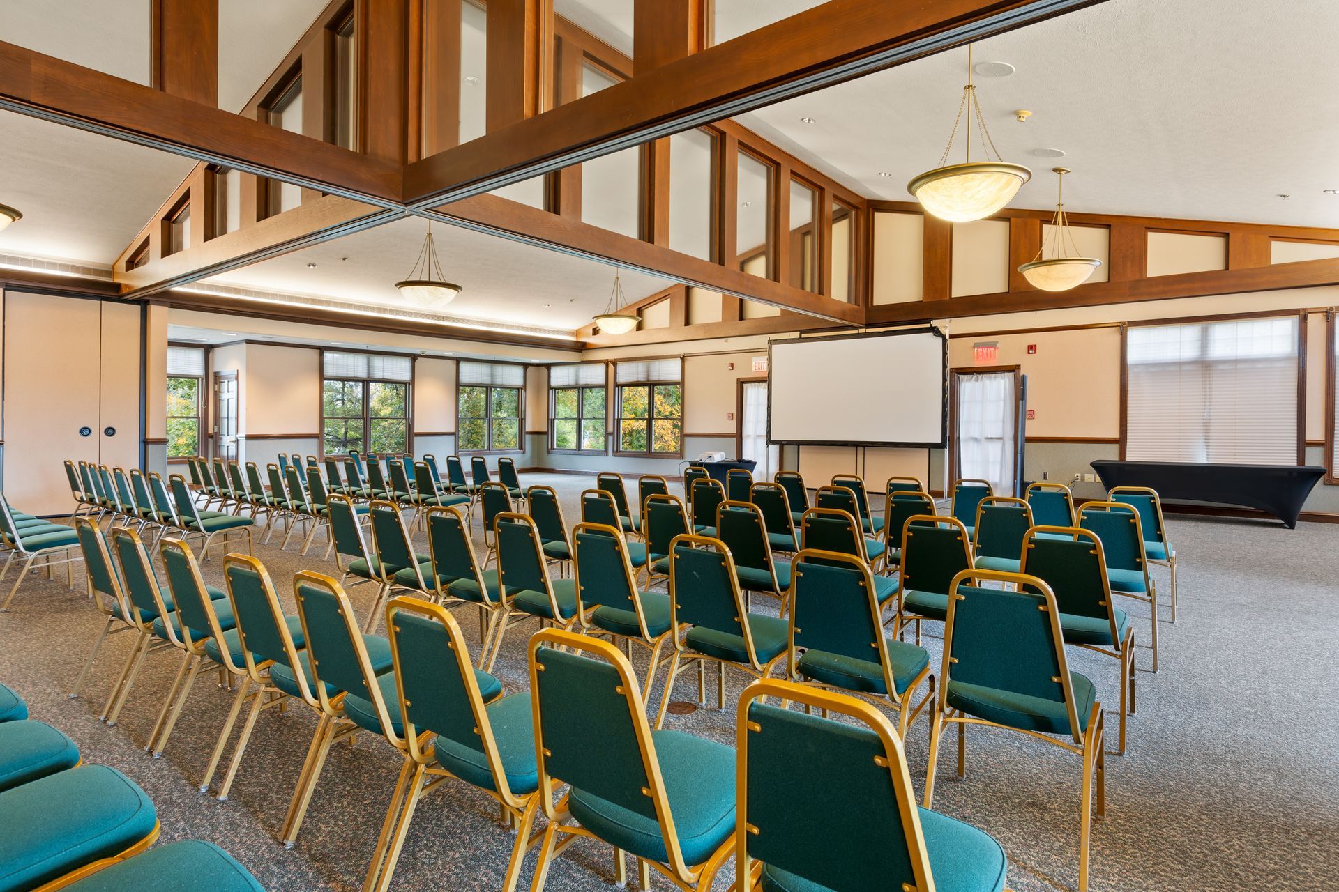 A large room with rows of chairs and a projector screen