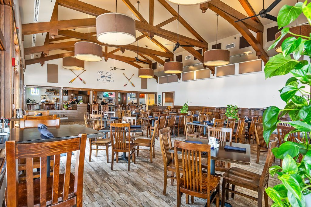 A large dining room filled with tables and chairs in a restaurant.