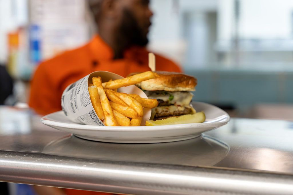 A plate of food with a sandwich and french fries on a counter.