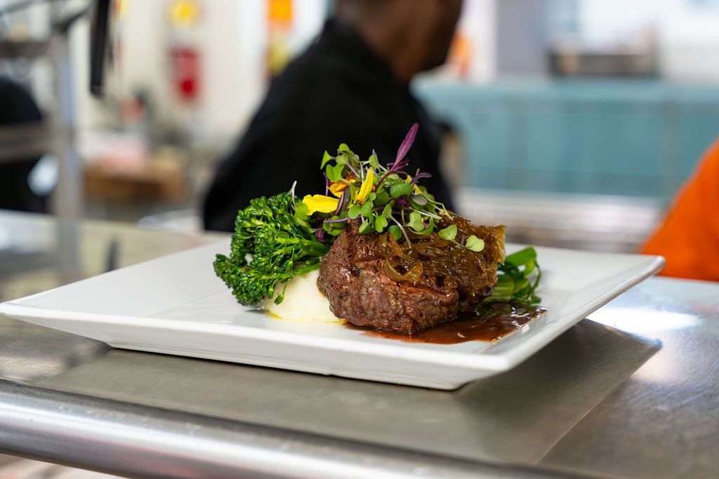 A plate of food with broccoli and mashed potatoes on a table.