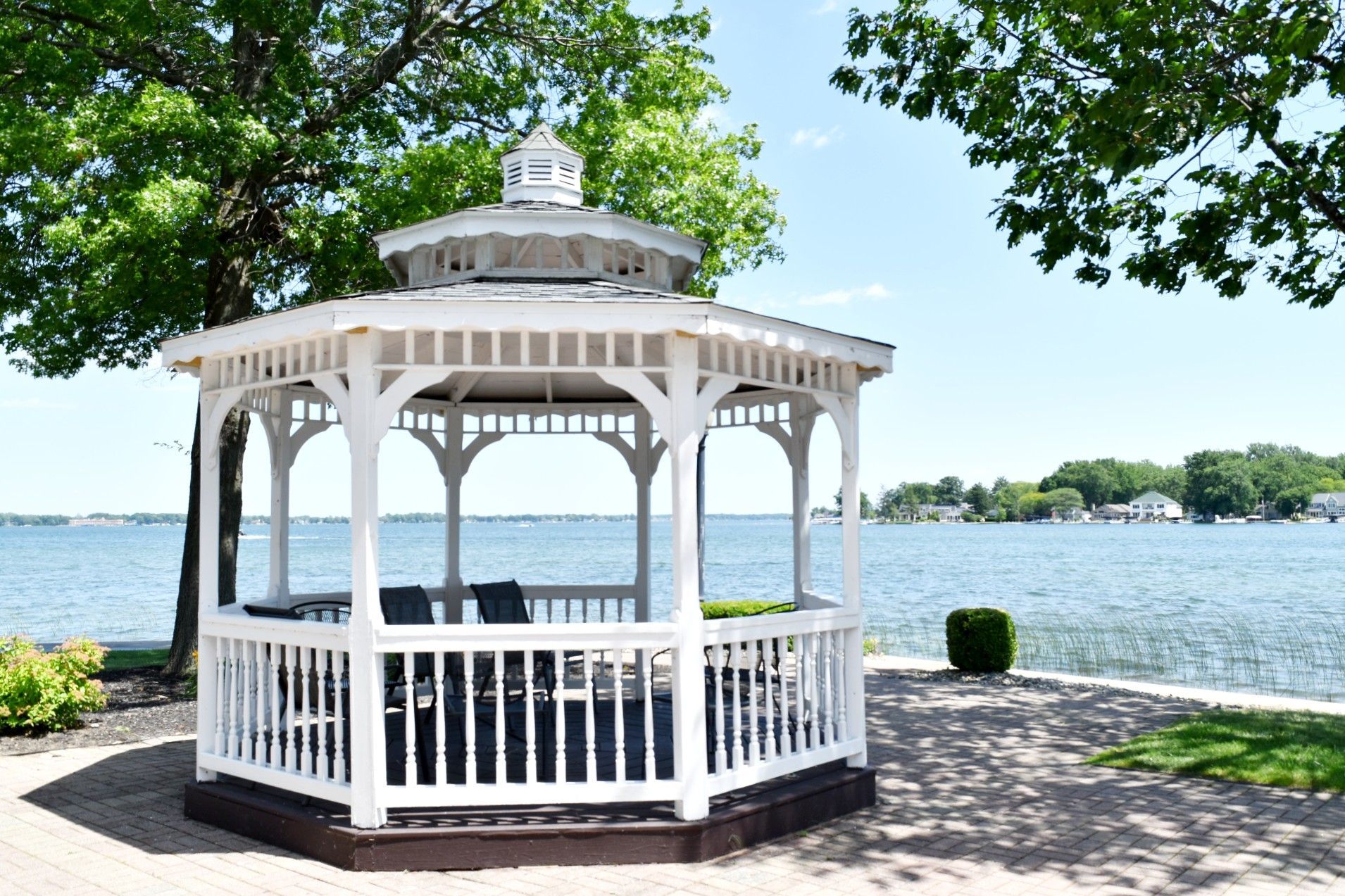 A white gazebo is sitting next to a body of water.