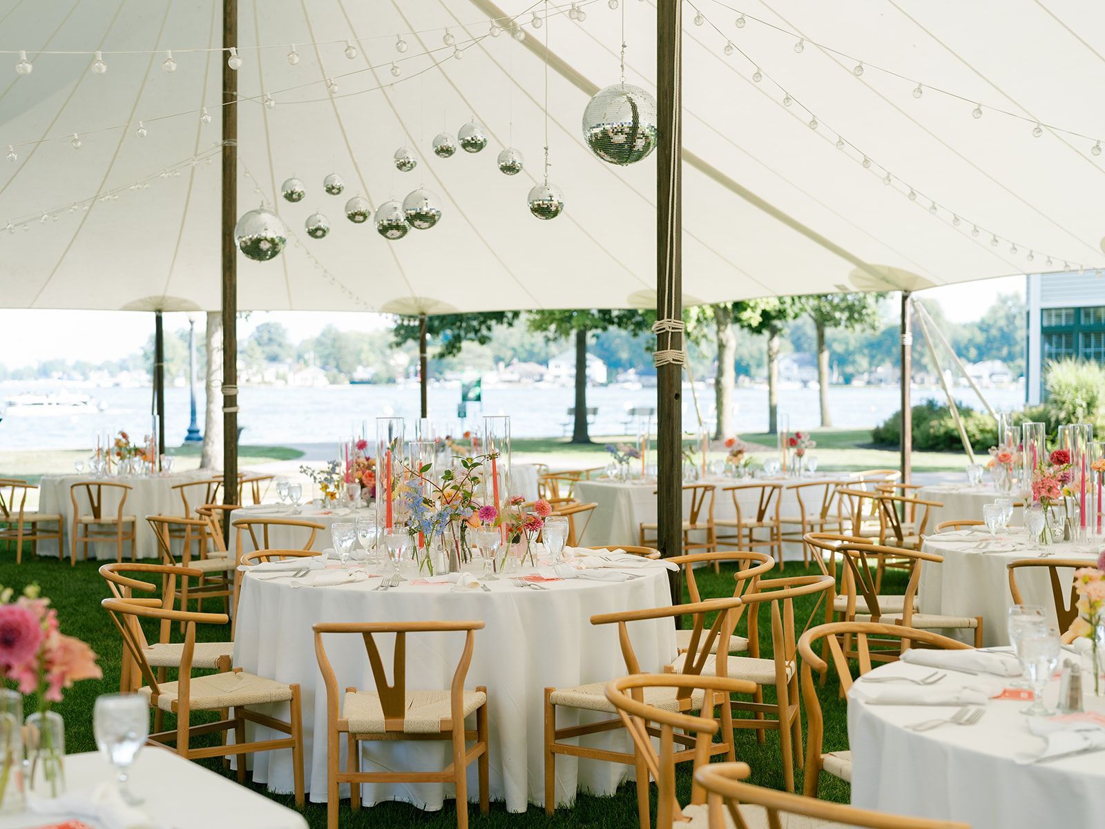 A large tent with tables and chairs set up for a wedding reception.