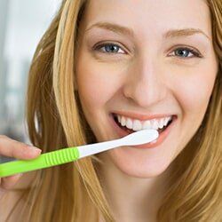Cosmetic Bonding — Woman Brushing Teeth in Burlington, IA