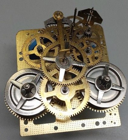 Uurwerkmechanisme met tandwielen en metalen onderdelen op een messing basis.