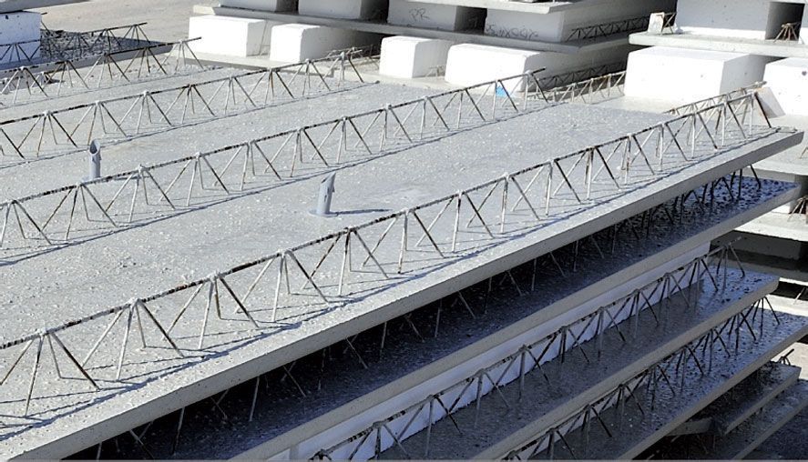 Solai prefabbricati in calcestruzzo impilati, con rinforzo in acciaio a vista.