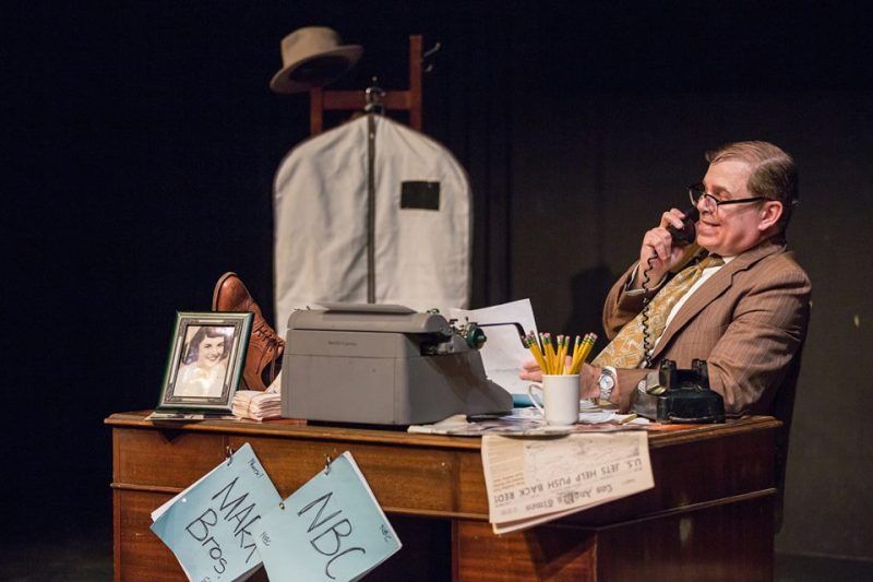 Bernie sitting behind desk with his feet up while on phone.