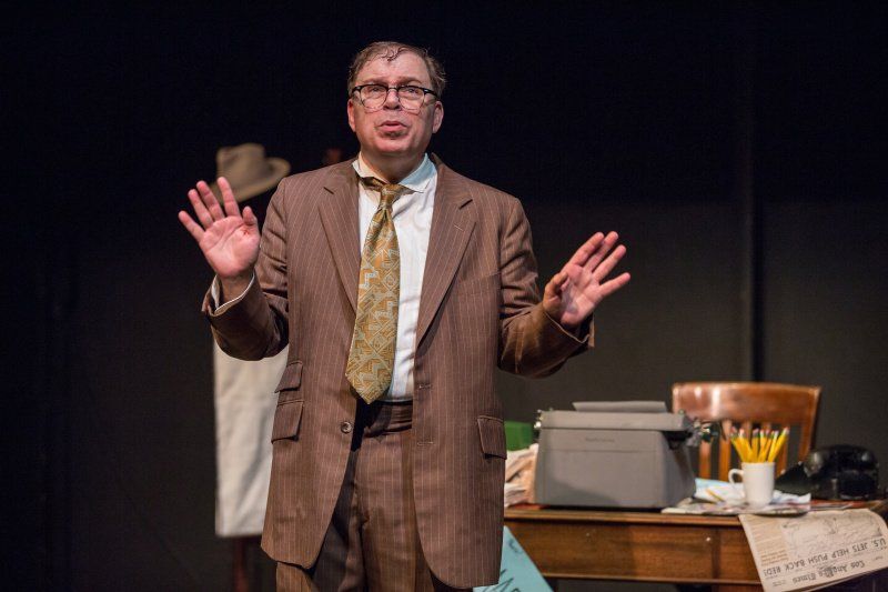 Bernie standing in front of his desk recalling a memory.