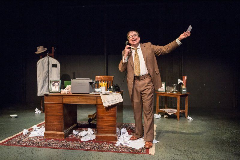 Bernie Lutz standing next to his desk sharing a joke on the phone.