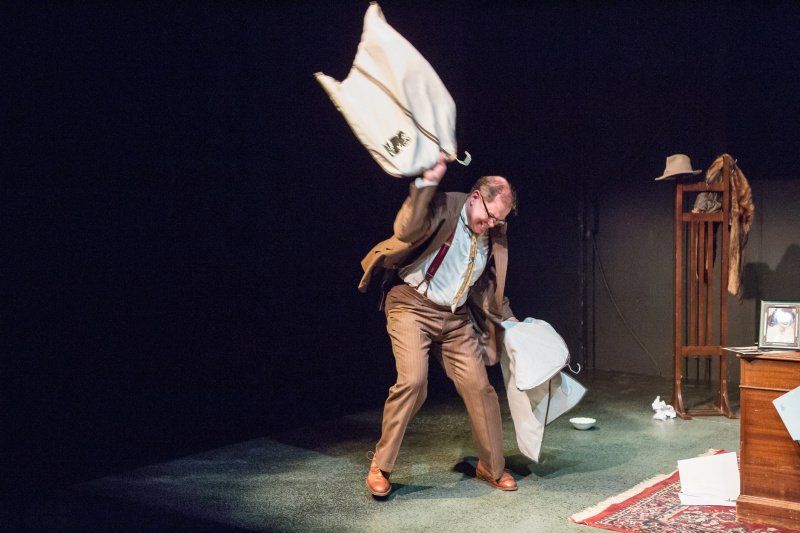 Bernie holding garment bag in left hand and getting throw it on floor