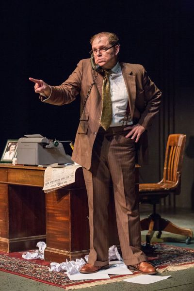 Bernie standing next to his desk while talking on the phone and making a point
