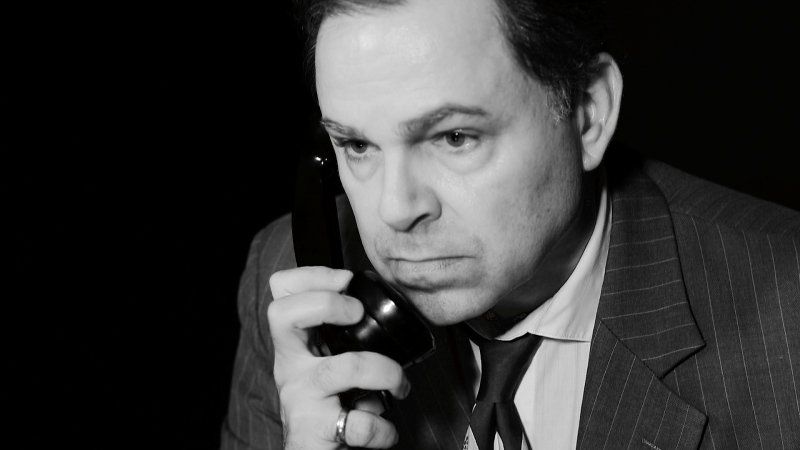 Bernie in close-up, looking concerned while on phone  he's holding to his right ear