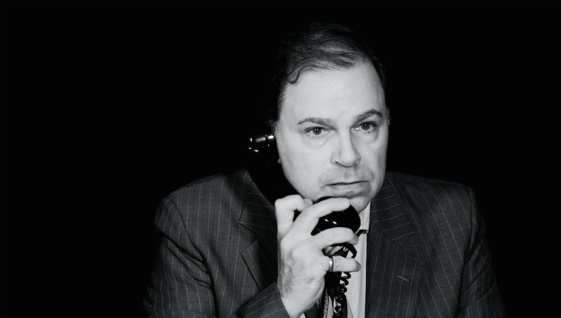 Close-up of Bernie listening on phone he's holding in right hand