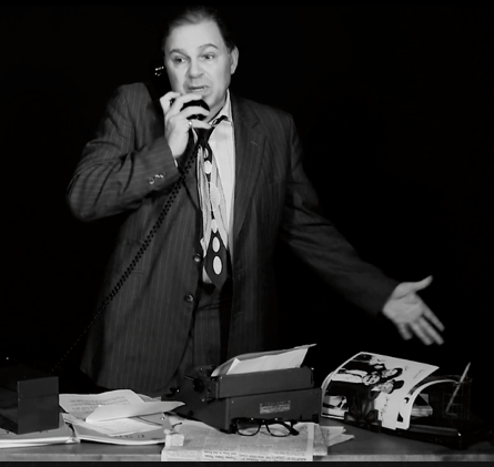 Bernie on the phone as he makes a point by gesturing with his left hand.