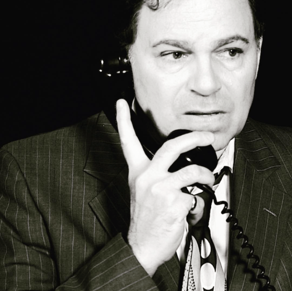 Bernie in black and white close-up as he  reacts to news he's hearing on phone