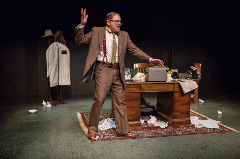 Bernie wearing a brown suit with suspenders and gesturing with his arms.