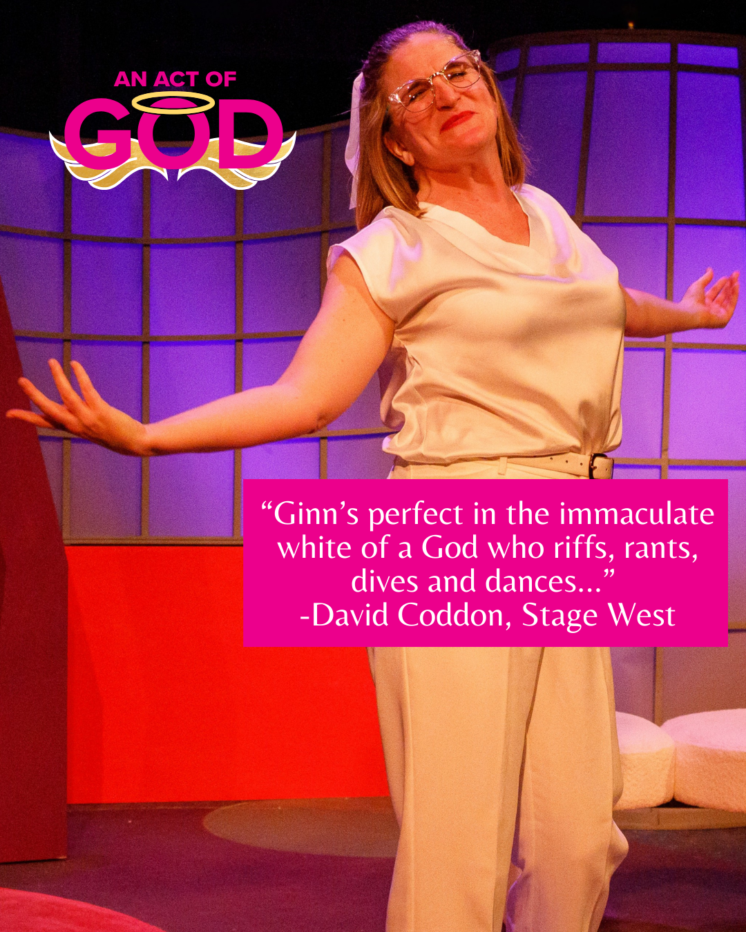 A performer in an all-white outfit stands on a stage with arms outstretched, beneath an