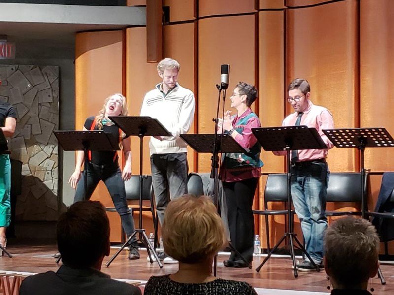 Woman in black shirt and suspenders acting silly during a scene with 3 other actors