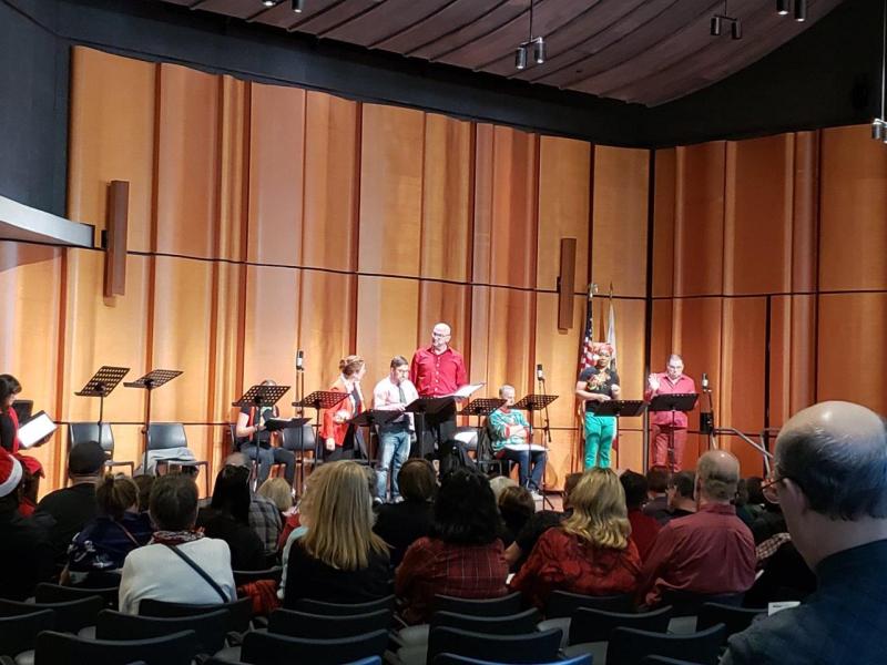 Attendees watching many actors on stage during play reading