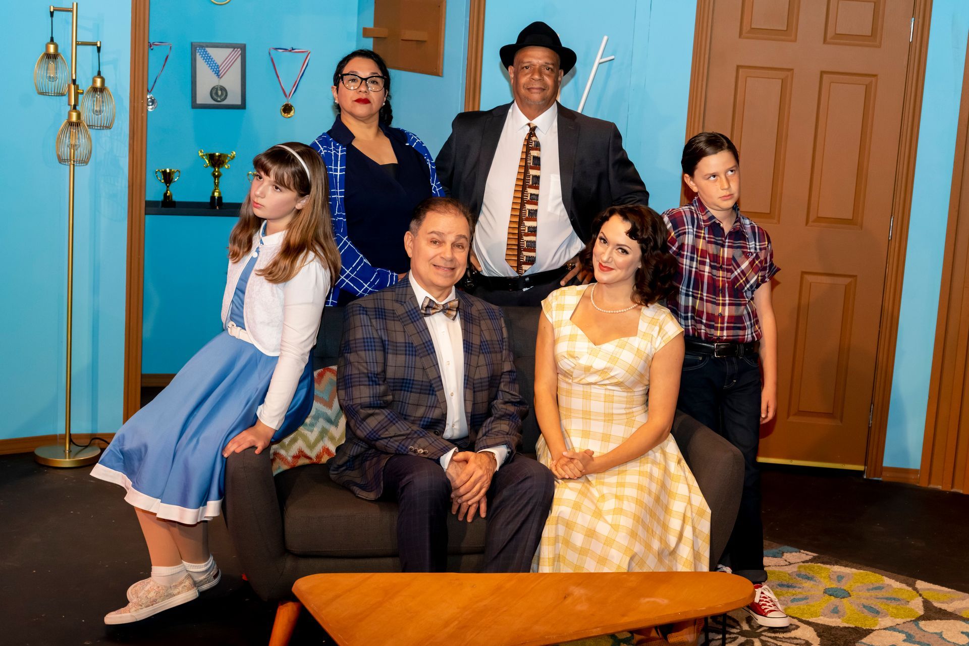 A group of people are posing for a picture in a living room.