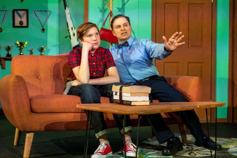 Father and son having a conversation about the future on orange sofa.