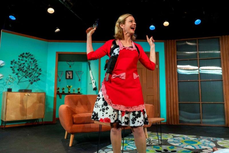 Mother in red apron and holding gun looking excited