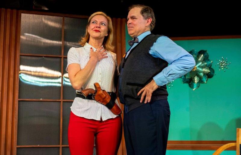 Mother in white blouse and gun belt and father in vest discussing their kids.