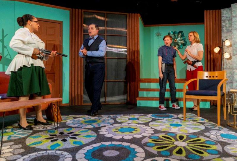 Social worker pointing a rifle at father in vest while son and mother look on.